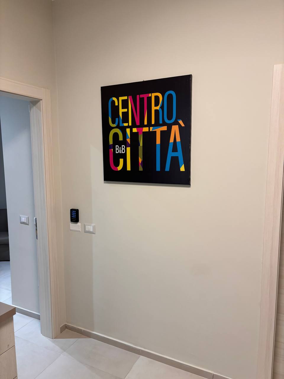 Ingresso del B&B Centro Città Crotone con la tela colorata del logo Centro Città B&B